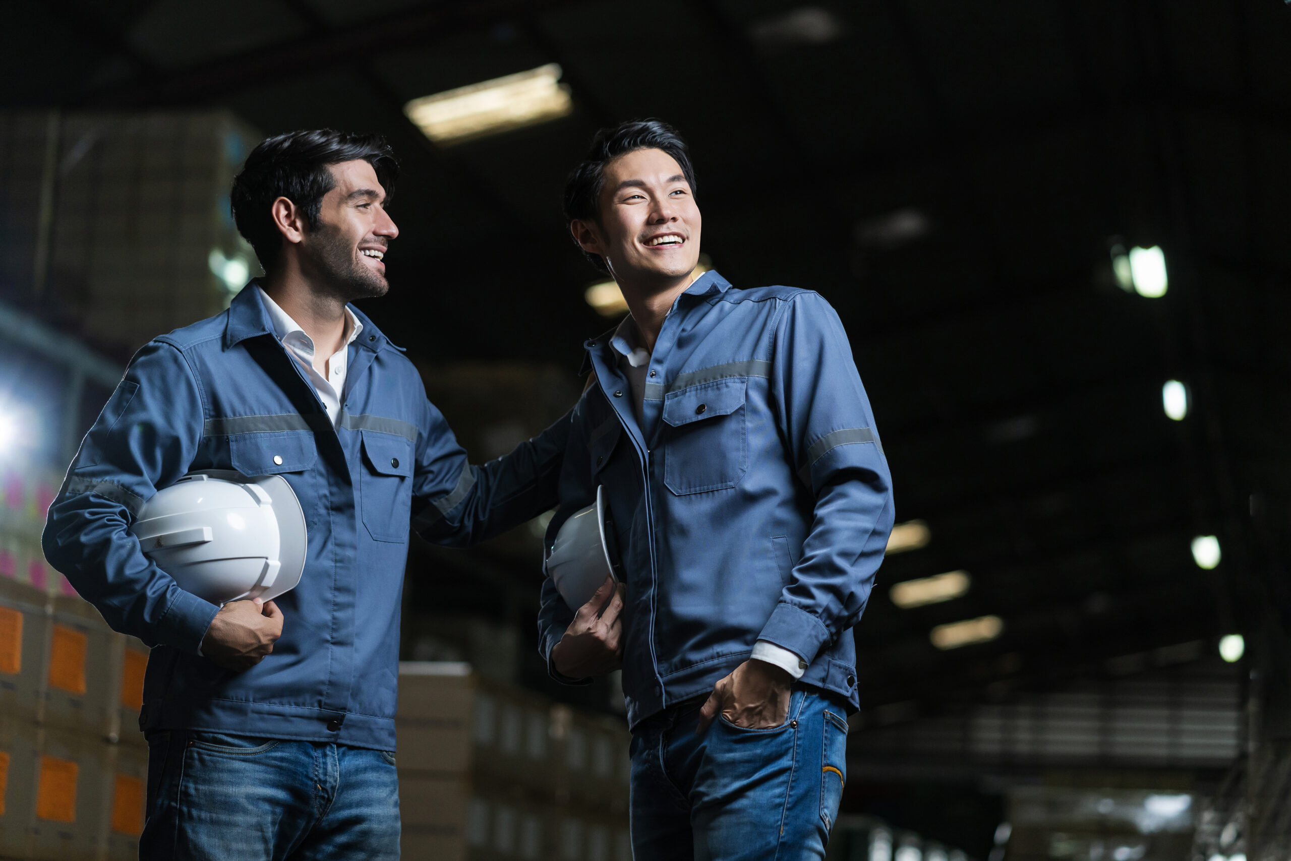 relax casual male asian and caucasian engineer staff worker in uniform happy conversation after work in warehouse distribution background